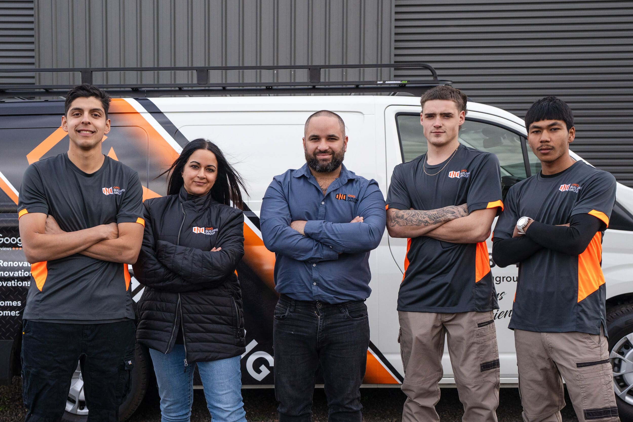 Team members of ONQ Building Group posing confidently in front of a branded work vehicle, showcasing family-led craftsmanship and dedication to home renovations in Melbourne.
